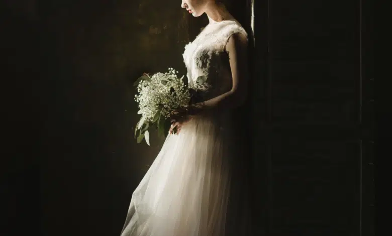 Consejos para elegir el mejor libro de fotos para tu boda 1 woman in wedding dress, dark background