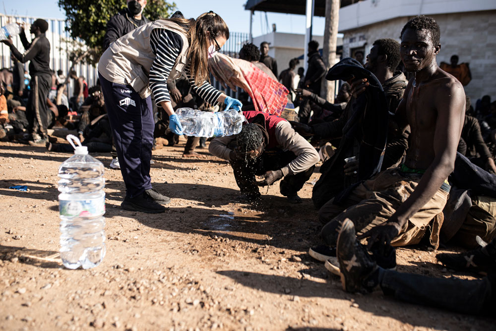 Más de 800 inmigrantes entran a la fuerza en territorio español del norte de África 3 Melilla, España, 2 de marzo de 2022: Un voluntario cuida a los migrantes que han cruzado con éxito la valla fronteriza en Melilla. Según la Guardia Civil, hasta 2.000 personas de regiones subsaharianas intentaron cruzar la valla fronteriza de Melilla, 500 de las cuales lo consiguieron y se dirigieron al Centro de Estancia Temporal de Migrantes (CETI). Foto: Ilies Amar/EUROPA PRESS/dpa,