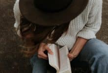 woman praying with bible, hipster hat