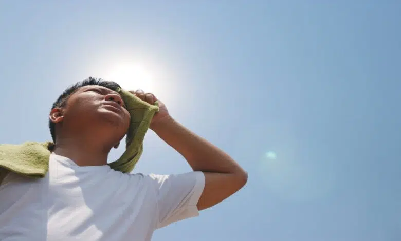 Los científicos nombran por primera vez las olas de calor 1 A man wiping sweat from his face under the hot sun.