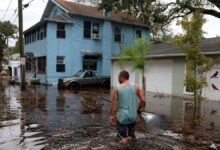 Jason Elam wades through flood waters around his home after Hurricane Nicole blew ashore on Nov. 10, 2022 in Daytona Beach, Florida.