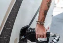 save fuel, man at petrol pump with tattoo