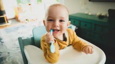 baby at highchair chewing on toothbrush